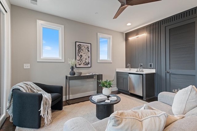 living room featuring light wood-type flooring, plenty of natural light, and sink