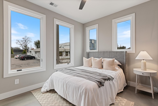 bedroom featuring multiple windows, hardwood / wood-style floors, and ceiling fan