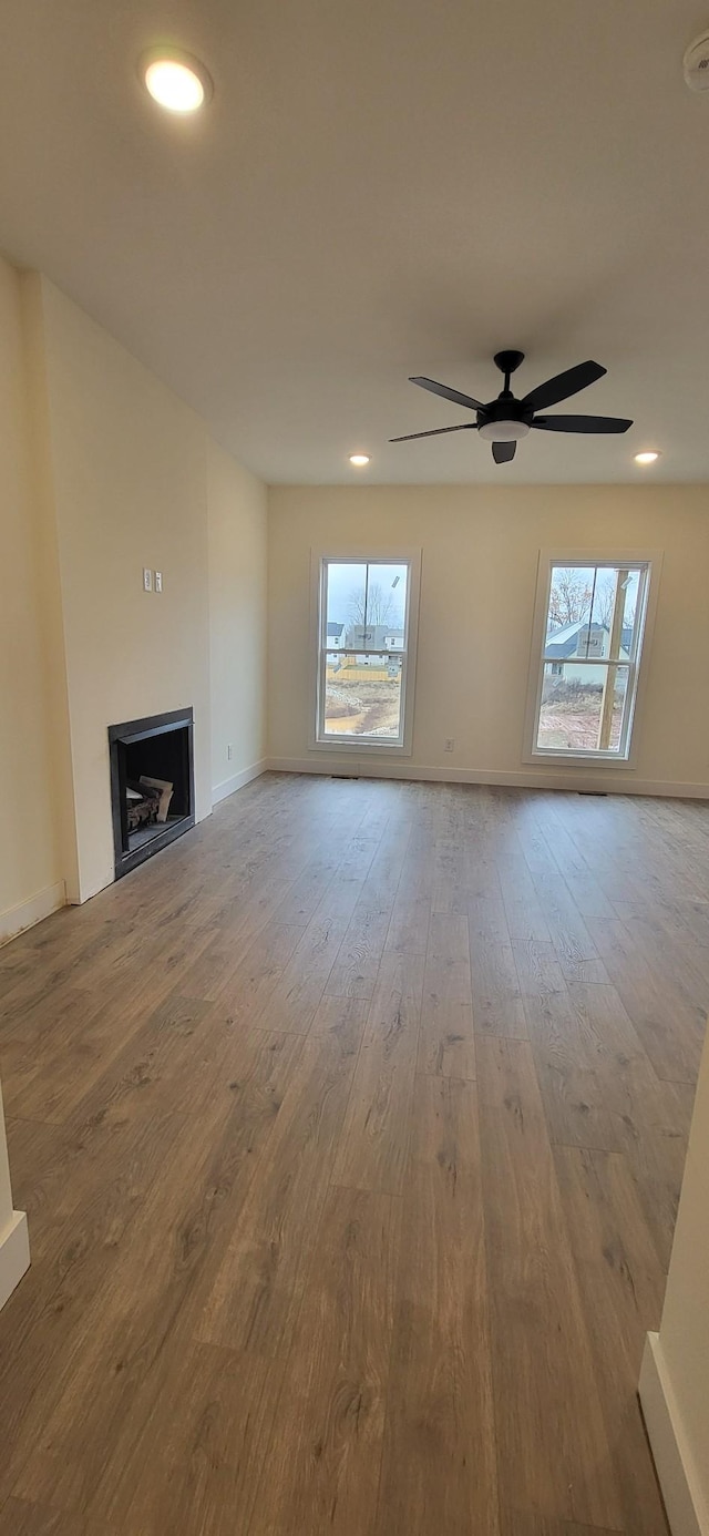 unfurnished living room with ceiling fan and light hardwood / wood-style floors