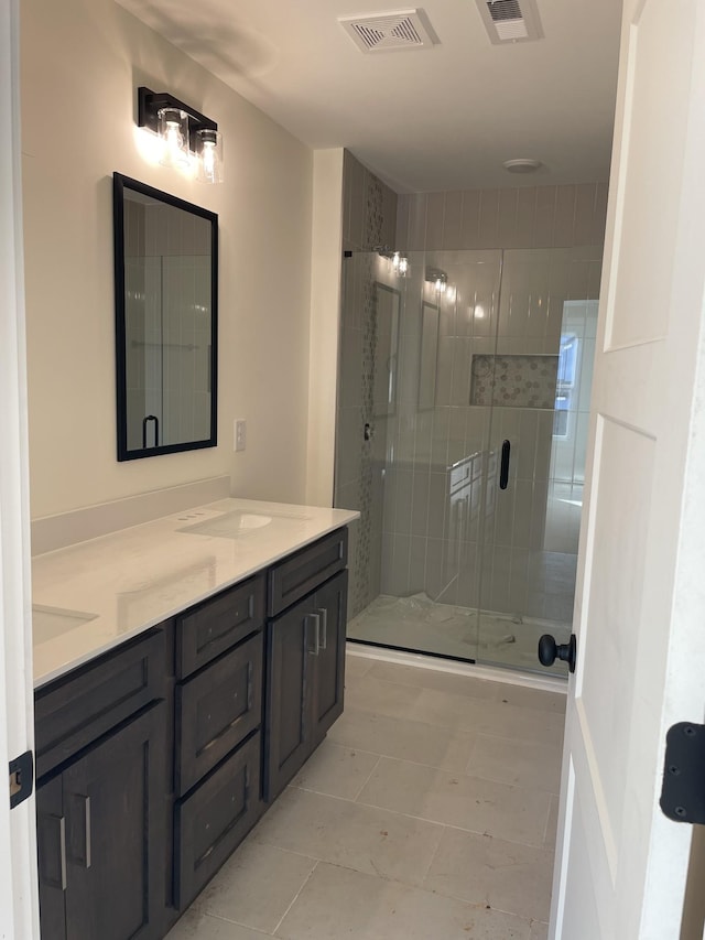 bathroom featuring a shower with door and vanity