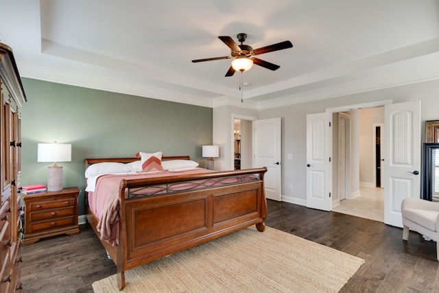 bedroom with dark hardwood / wood-style flooring, a raised ceiling, ceiling fan, and crown molding