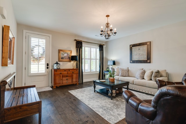 living room with dark hardwood / wood-style flooring and an inviting chandelier