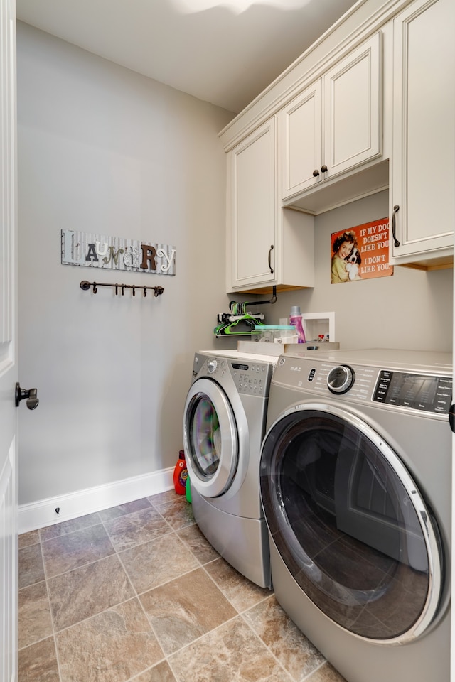 washroom with washer and dryer and cabinets