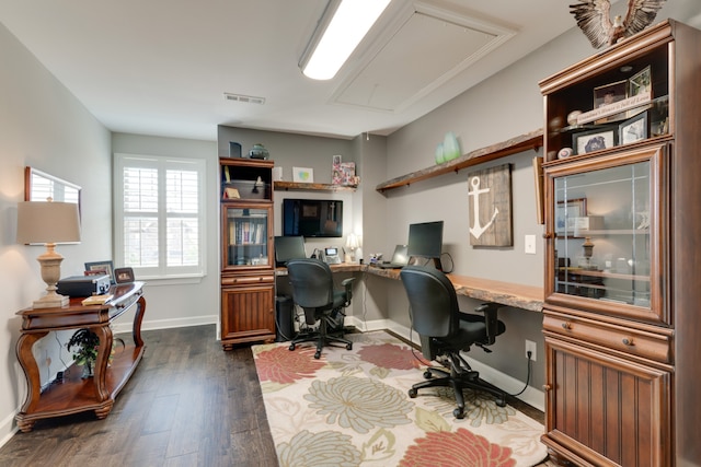 office space featuring dark hardwood / wood-style flooring and built in desk