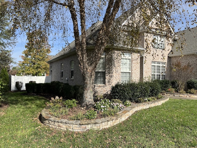 view of side of property with a lawn