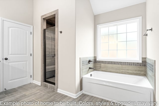 bathroom featuring shower with separate bathtub