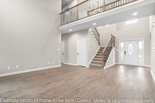 entrance foyer featuring wood-type flooring and a high ceiling