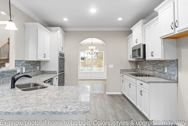 kitchen with sink, white cabinetry, decorative light fixtures, ornamental molding, and appliances with stainless steel finishes