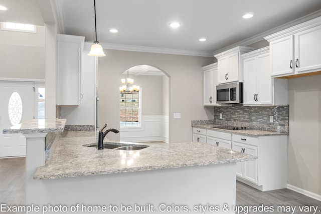 kitchen with sink, white cabinets, hanging light fixtures, crown molding, and black electric cooktop