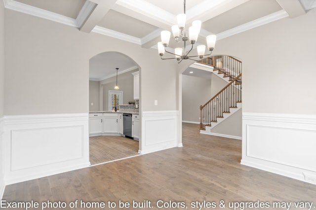 interior space featuring white cabinetry, decorative light fixtures, stainless steel dishwasher, ornamental molding, and beamed ceiling