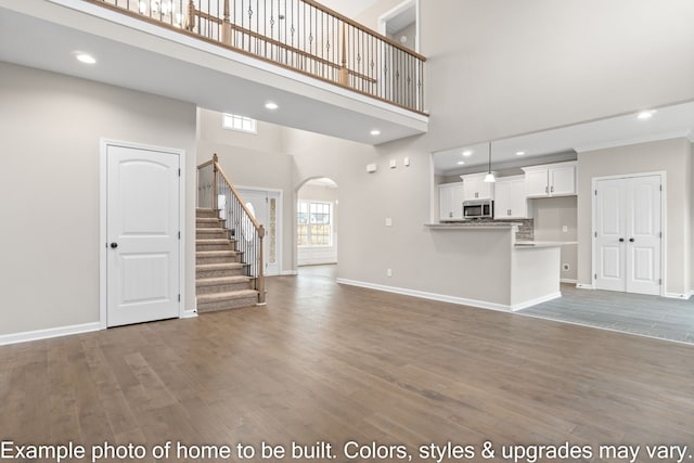 unfurnished living room with hardwood / wood-style floors and a high ceiling