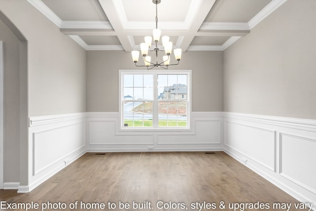 spare room with coffered ceiling, beam ceiling, light hardwood / wood-style floors, and a chandelier