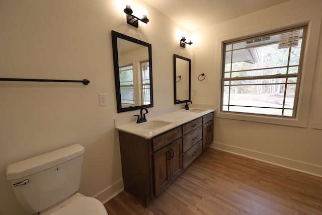 bathroom with hardwood / wood-style floors, vanity, and toilet