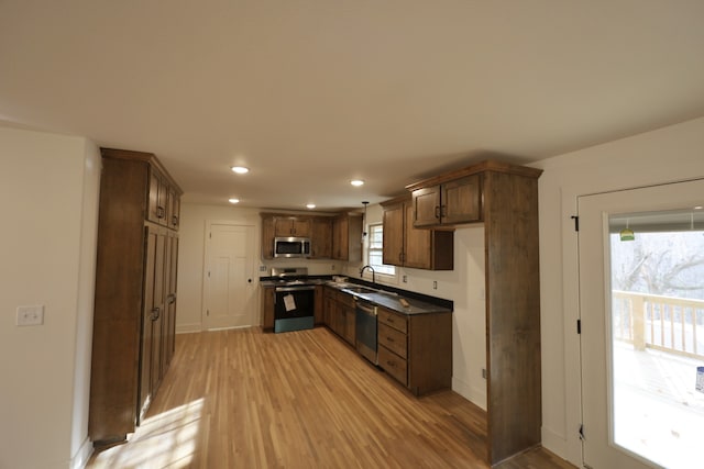 kitchen featuring a healthy amount of sunlight, light wood-type flooring, sink, and appliances with stainless steel finishes