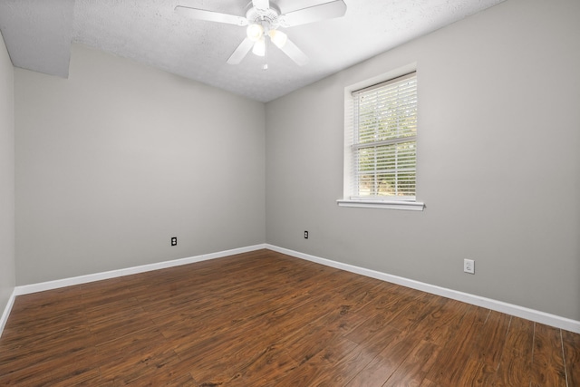 spare room with a textured ceiling, ceiling fan, and dark wood-type flooring