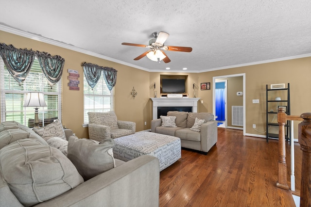 living room with a textured ceiling, dark hardwood / wood-style flooring, ceiling fan, and ornamental molding