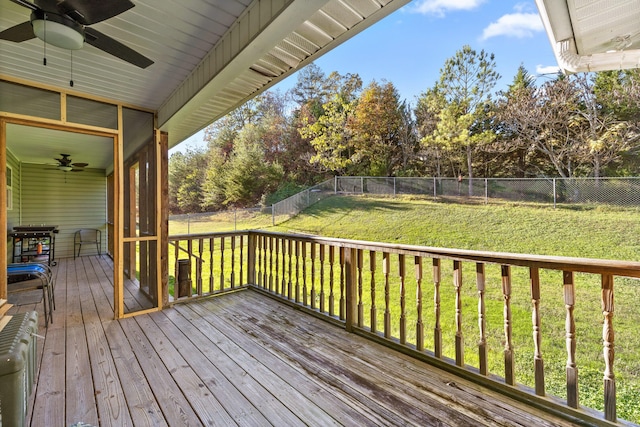 wooden deck featuring ceiling fan and a yard