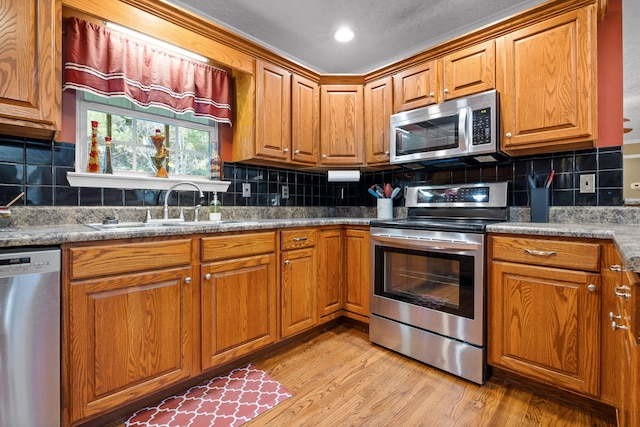 kitchen with decorative backsplash, light hardwood / wood-style flooring, and appliances with stainless steel finishes