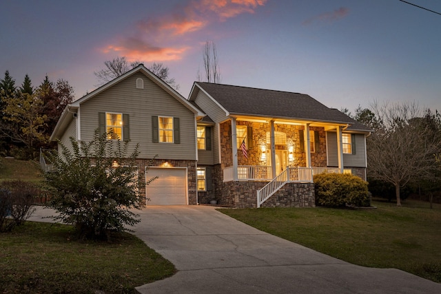 raised ranch featuring a lawn, a porch, and a garage