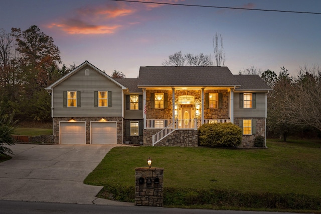 bi-level home featuring covered porch, a yard, and a garage