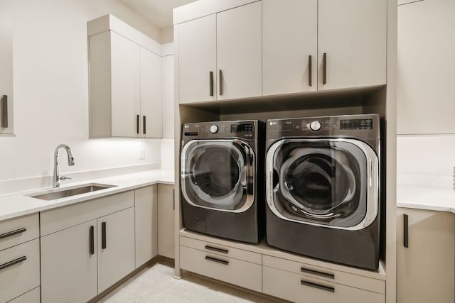 laundry area with washer and dryer, cabinets, and sink