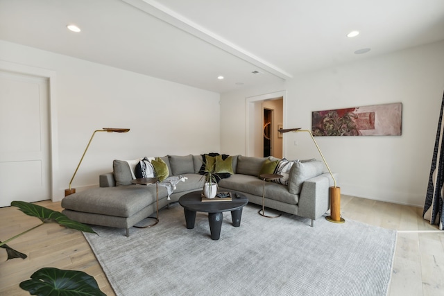 living room featuring beam ceiling and light wood-type flooring