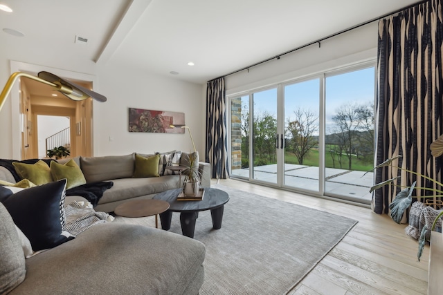 living room featuring beam ceiling, ceiling fan, and light hardwood / wood-style floors