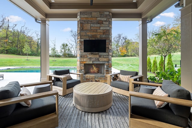 view of patio / terrace with an outdoor stone fireplace and a pool