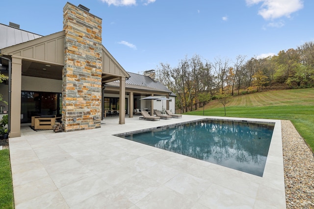 view of swimming pool featuring a patio area and a lawn