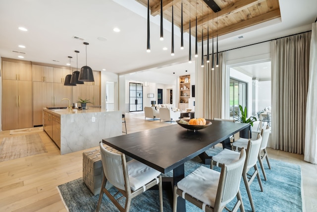 dining area featuring wood ceiling, sink, beamed ceiling, and light hardwood / wood-style floors