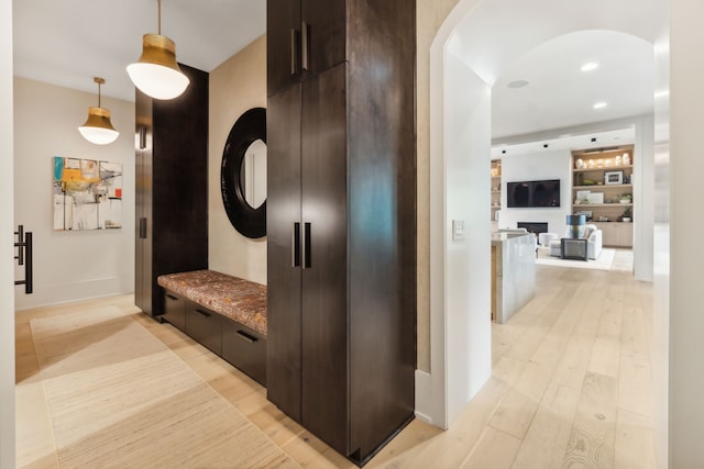 corridor featuring light hardwood / wood-style floors and built in features