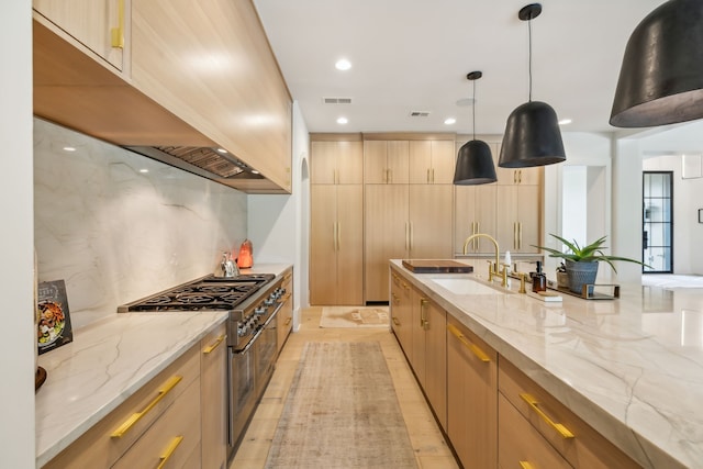 kitchen with stainless steel range, light brown cabinets, and light stone counters