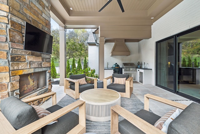 view of patio / terrace featuring an outdoor stone fireplace, area for grilling, sink, and ceiling fan