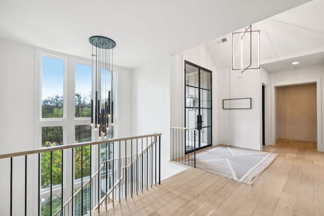 interior space featuring plenty of natural light, light hardwood / wood-style floors, and a chandelier