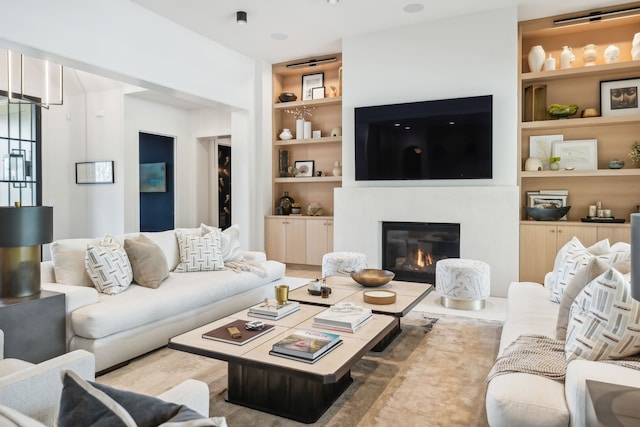 living room with built in shelves and light wood-type flooring