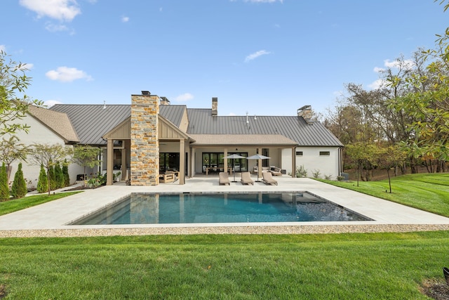 rear view of property featuring a lawn and a patio area