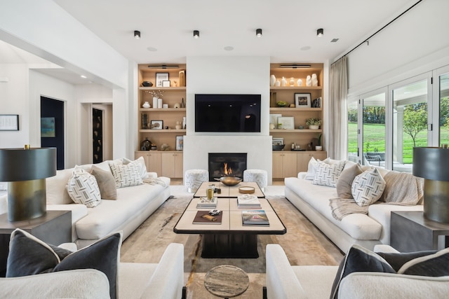 living room with built in shelves and light wood-type flooring