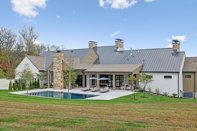 rear view of property with a yard, an outdoor living space, central AC unit, and a patio area