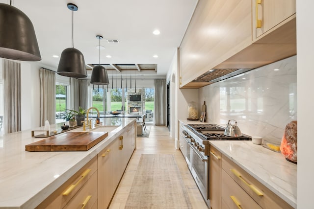 kitchen featuring pendant lighting, double oven range, plenty of natural light, and light hardwood / wood-style floors