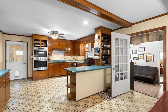 kitchen with ceiling fan, stainless steel appliances, beamed ceiling, kitchen peninsula, and ornamental molding