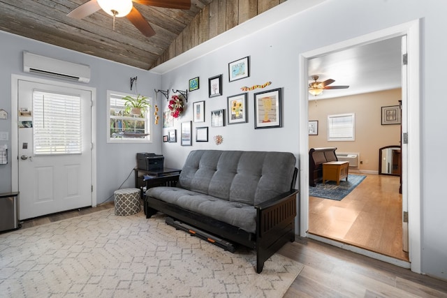 living area featuring a wall mounted air conditioner, light wood-type flooring, ceiling fan, and lofted ceiling