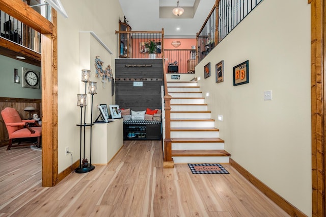 stairs featuring hardwood / wood-style floors and a towering ceiling