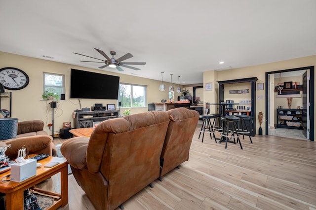 living room with ceiling fan and light hardwood / wood-style flooring