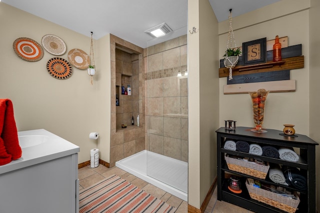 bathroom featuring tile patterned floors, vanity, and a tile shower