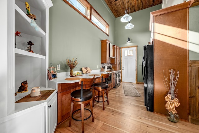 kitchen with pendant lighting, wooden ceiling, black refrigerator, light hardwood / wood-style flooring, and stainless steel electric range oven