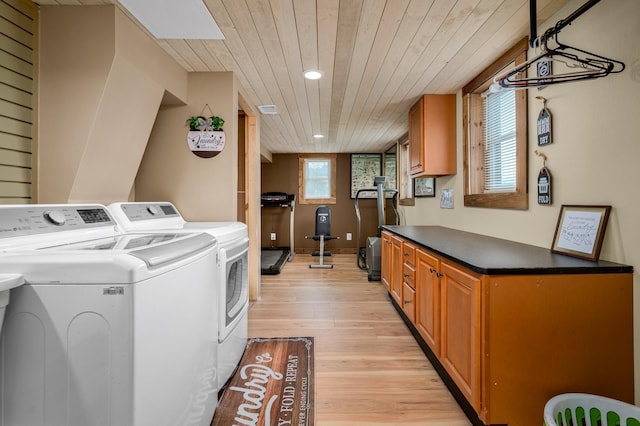 washroom with washing machine and dryer, light hardwood / wood-style floors, and wooden ceiling