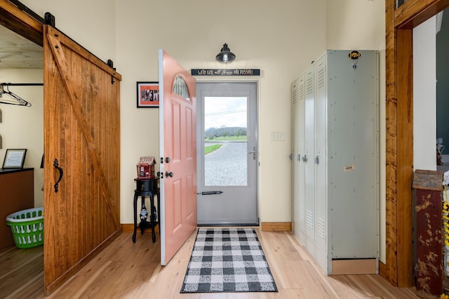 foyer with light wood-type flooring and a barn door