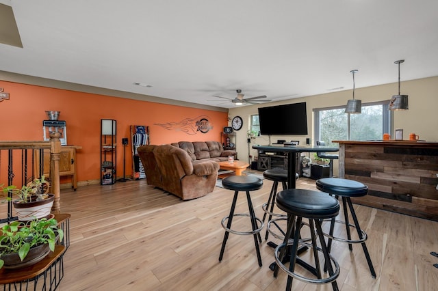 living room with light wood-type flooring and ceiling fan