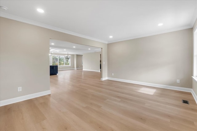 unfurnished living room with a notable chandelier, light hardwood / wood-style floors, and ornamental molding