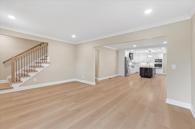 unfurnished living room with light hardwood / wood-style flooring and crown molding